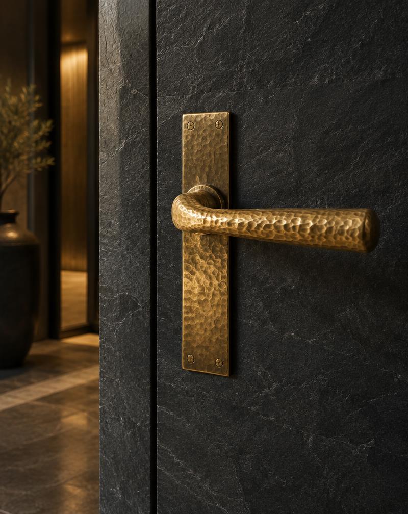 Hammered brass detail on a dark stone door